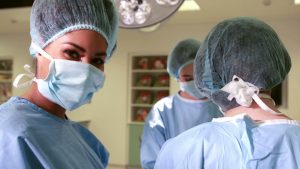 Médecins équipés d'une charlotte, d'un masque, d'une blouse et d'autres équipemetns de protection pour procéder à une opération